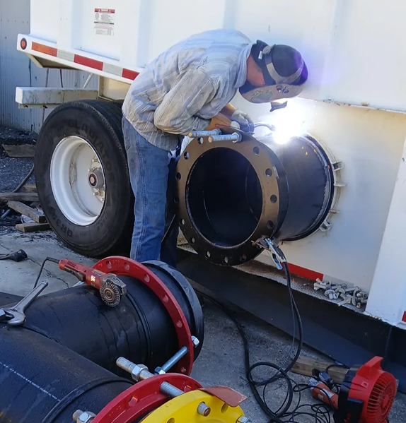 Welder working on industrial pipe