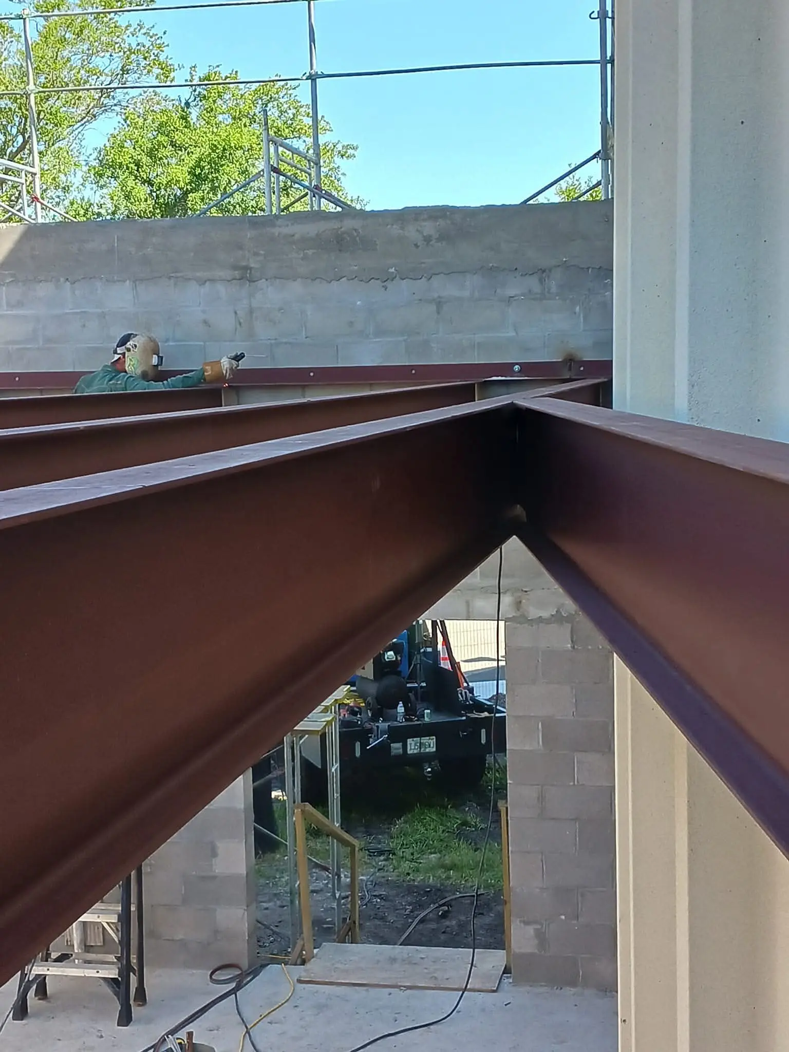 Steel beams installed at a construction site between concrete walls.