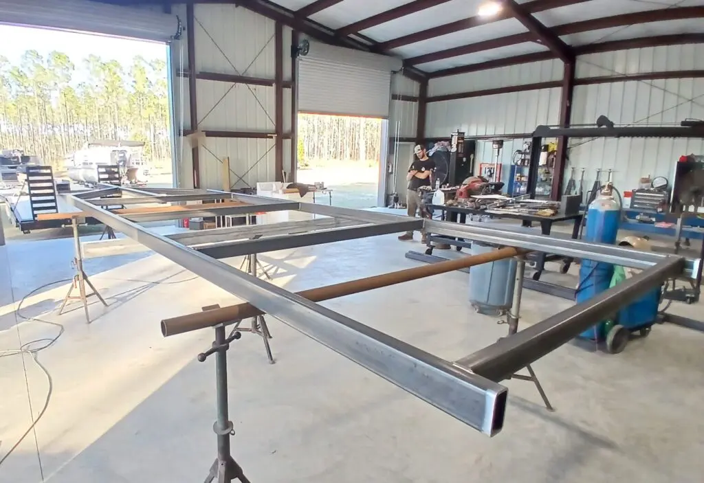 Metal beams arranged on stands inside a workshop under construction.